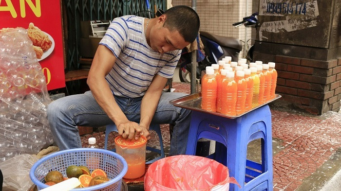 Với giá thành rẻ, có thể tấp xe vào lề đường để mua nhanh, nên những sản phẩm nước ép hoa quả bán vỉa hè rất hút khách trong những ngày nắng nóng. Ảnh: Người tiêu dùng.