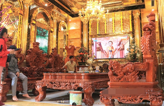Bên trái phòng khách là bộ bàn ghế gỗ đồ sộ. Ảnh: Dân Việt