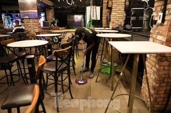 Nhân viên nhà hàng tranh thủ lau dọn quán trước ki đóng cửa..