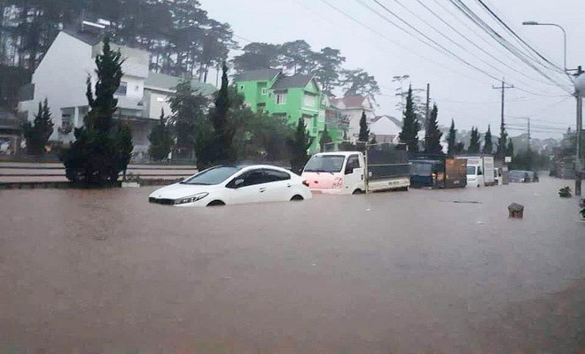 Bên ngoài đường lớn tại Đà Lạt, một số người phải vật lộn với xe chết máy, phải dẫn bộ cả đoạn dài. Ô tô cũng không khá hơn khi nước cũng đã ngập đến gần một nửa.