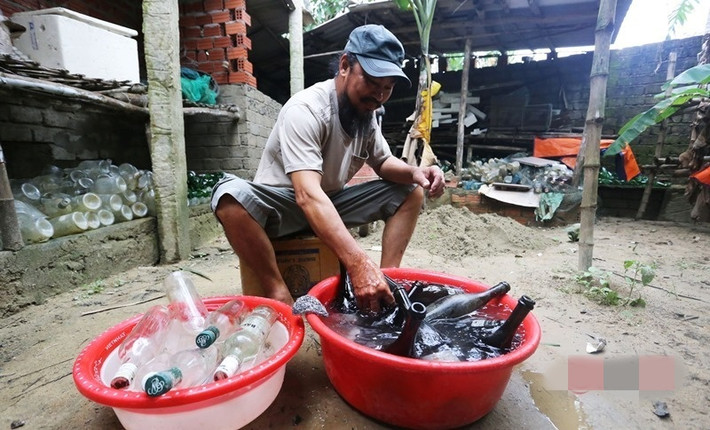 Trước khi dùng vỏ chai làm nhà, ông Linh phân loại và rửa sạch. Mỗi chai, ông đổ nước sạch vào trong rồi đậy nắp lại. Ảnh: Infonet