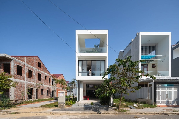 Thay vì tận dụng hết quỹ đất để xây dựng, kiến trúc sư và gia chủ quyết định lùi toàn bộ 4 mặt ngôi nhà, chừa một khoảng đất bao quanh để trồng cây, tạo thảm cỏ xanh mướt. Ảnh: Triệu Chiến