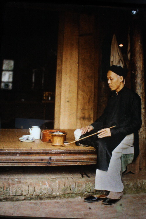 Cụ già sửa soạn thuốc lào.