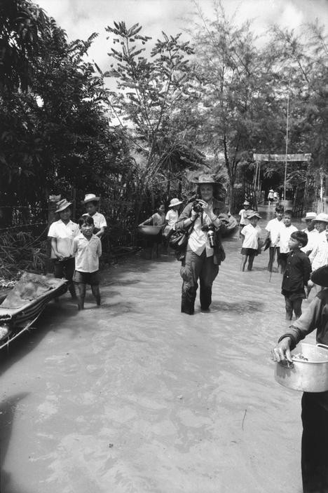 Nữ nhiếp ảnh gia tác nghiệp trên con đường bị ngập lụt.
