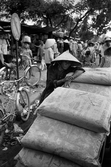 Một người lao động mệt mỏi ngoài lên bao hàng để nghỉ lấy hơi.