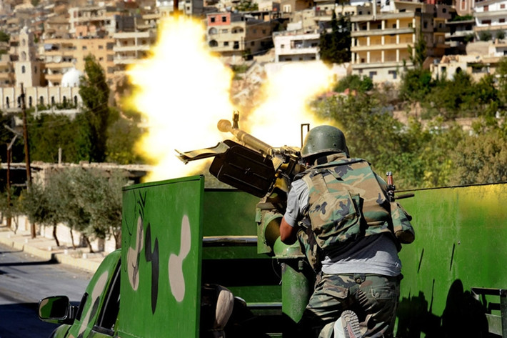 Lính chính phủ dùng súng máy nã đạn vào phiến quân ở Maaloula, Đông Bắc Damascus, ngày 7/9/2013.