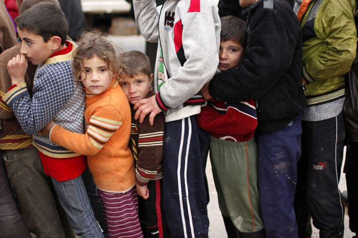 Trẻ em Syria xếp hàng nhận đồ cứu trợ ở một trại tị nạn bên trong lãnh thổ Syria, gần biên giới Thổ Nhĩ Kỳ.