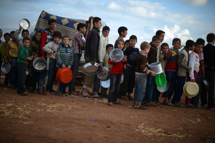 Những người tị nạn Syria xếp hàng để nhận khẩu phần ăn tại trại tị nạn Maiber al-Salam gần biên giới Thổ Nhĩ Kỳ. Theo ước tính, hiện có tới 4,5 triệu người chạy loạn ở bên trong lãnh thổ Syria.
