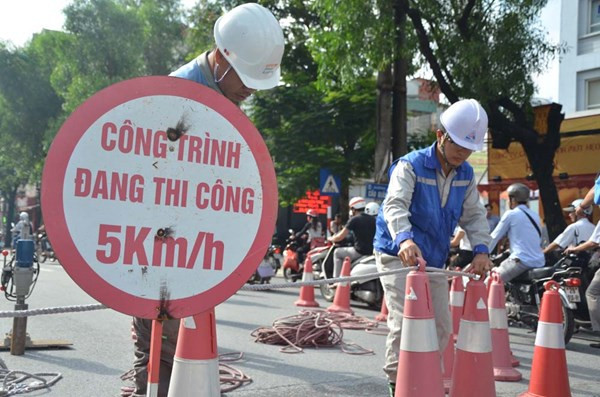 Tới 8h15 phút, đơn vị thi công bắt đầu dựng rào chắn tại trụ cầu ga số 7 (điểm giao cắt giữa đường Cầu Giấy - Trần Đăng Ninh). Ảnh: Đơn vị thi công dựng hàng rào chắn đường tại trụ cầu ga số 7, phục vụ thi công công trình. Nguồn: Tiền Phong.