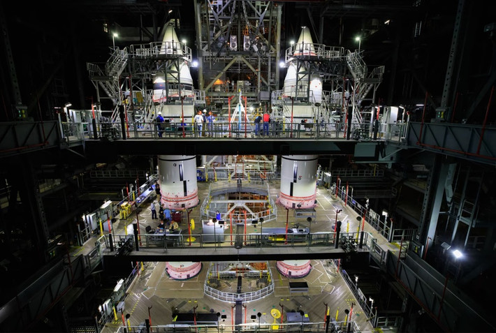 br/> Tại cơ sở High Bay 3, Trung tâm Lắp ráp Phương tiện ở Trung tâm Vũ trụ Kennedy, các bộ phận của tên lửa đẩy SLS được hạ xuống bệ phóng di động ngày 3/3/2021. Ảnh: NASA.