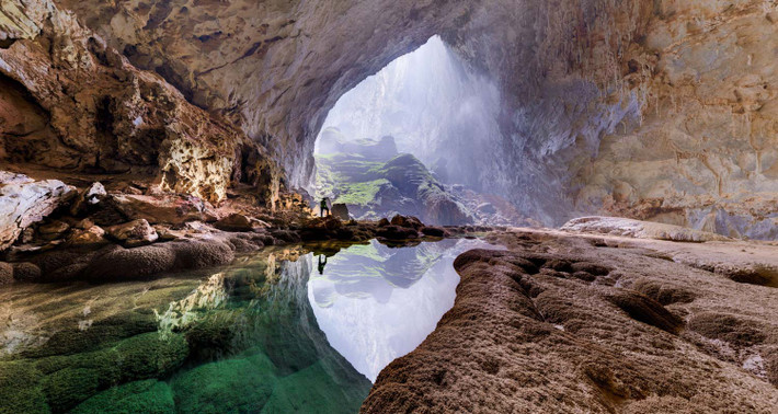 Sơn Đoòng hình thành trên một đoạn đứt gãy của dãy Trường Sơn và bị dòng nước sông Rào Thương ăn mòn qua hàng triệu năm, tạo thành đường hầm khổng lồ bên dưới lớp núi đá vôi. Những vết nứt trên trần hang bị ăn mòn và sụt lún, tạo thành những hố sụt lớn thông ra bên ngoài. Bên trong không gian kỳ vĩ ấy là cả một thế giới tách biệt, cả một kỳ quan thiên nhiên hiếm có khiến cho các nhà chinh phục Sơn Đoòng phải sửng sốt. (Ảnh: National Geographic).