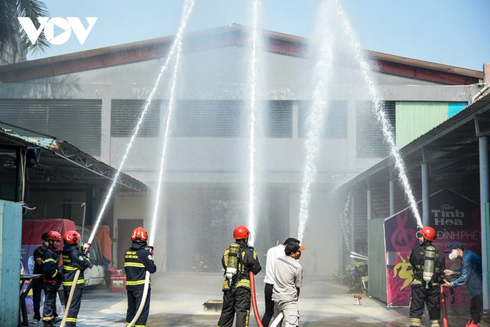 Cảnh sát phòng cháy chữa cháy phun nước dập lửa.