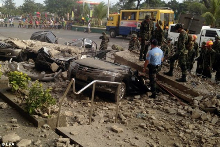 Binh lính Philippines tìm kiếm nạn nhân trong xe bị khối bê tông đè bẹp bên ngoài một trung tâm mua sắm.