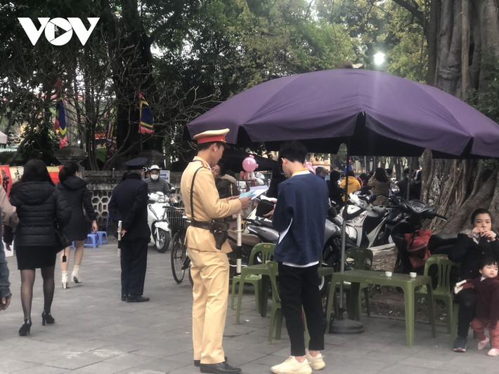 Cảnh sát kiểm tra một trường hợp đỗ xe trước cửa Đền Quán Thánh. Theo phân cấp, các điểm trông giữ xe dưới lòng đường Sở GT-VT quản lý, trên vỉa hè các quận, huyện quản lý. Để phục vụ nhu cầu của thăm viếng chùa đầu năm của người dân xung quanh các di tích được quận cấp phép tạm trông giữ phương tiện. Tuy nhiên, thực tế nhiều điểm trông giữ phương tiện sử dụng quá diện tích cấp, tranh thủ trông giữ cả ô tô trên vỉa hè, dưới lòng đường./.