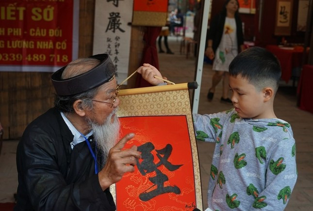 Ông đồ cho chữ tại Văn Miếu - Quốc Tử Giám (Hà Nội). Ảnh: Tân Hoa Xã