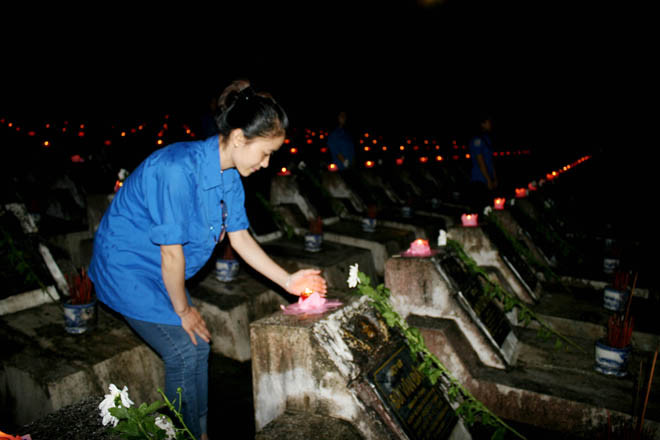 Các đoàn viên, thanh niên tình nguyện chăm chút từng cây nến, cành hoa trên mộ các liệt sỹ.