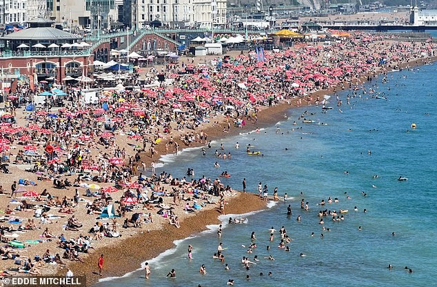 Bãi biển đông đúc ở Brighton, Anh, khi người dân đổ xô đến đây để giải nhiệt ngày nắng. Ảnh: Eddie Mitchell.