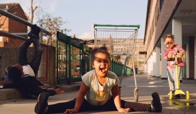 Bé gái cười tươi trước ống kính.