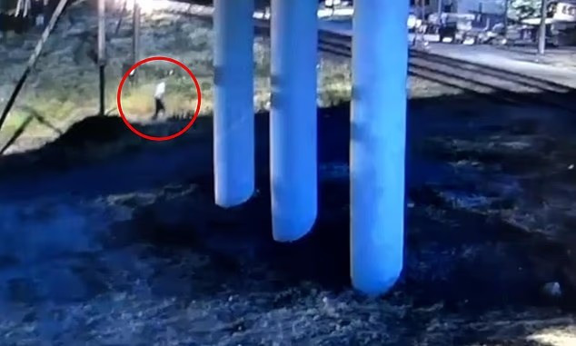 Theo Daily Mail, vụ việc xảy ra gần đây tại thành phố Derbent của Nga. Đoạn video ghi lại sự việc cho thấy, một người đàn ông mặc áo sơ mi trắng và quần tối màu tiến về phía đường ray, sau đó ngã gục trước đầu một đoàn tàu đang lao tới. (Nguồn ảnh: DM, East2West)