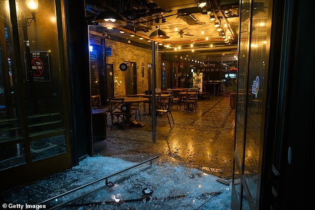 Cửa kính vỡ tại khu chợ Sarona ở Tel Aviv ngày 13/6. Ảnh: Getty.