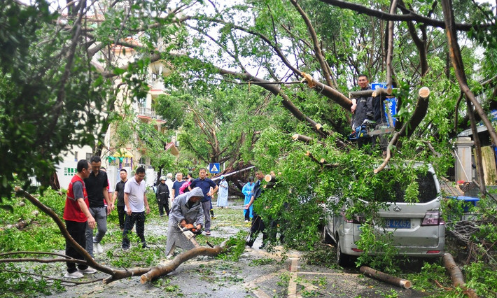 Lực lượng cứu hộ và tình nguyện viên địa phương cùng nhau dọn dẹp các chướng ngại vật trên đường do bão Kajiki gây ra ở Tam Á. Ảnh: VCG.