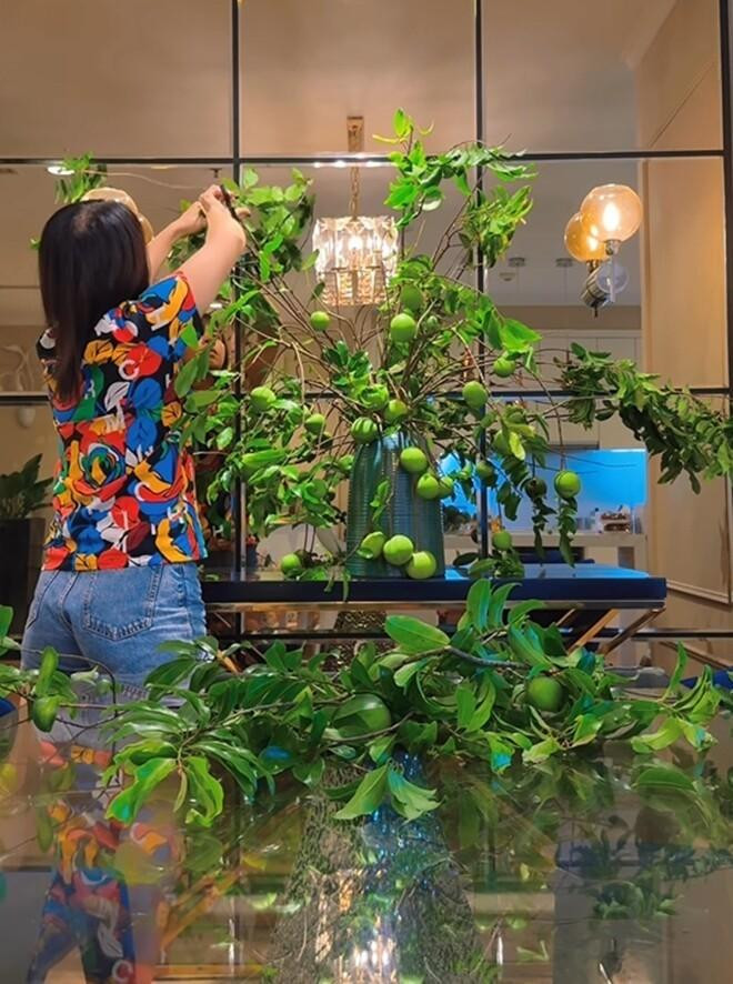 ác cành thị được sắp xếp theo dạng tự nhiên. Bà mẹ 3 con khéo léo uốn nắn cành để chúng lan tỏa từ trung tâm ra ngoài, tạo thành một bố cục đối xứng nhẹ nhàng nhưng vẫn mang tính nghệ thuật cao.