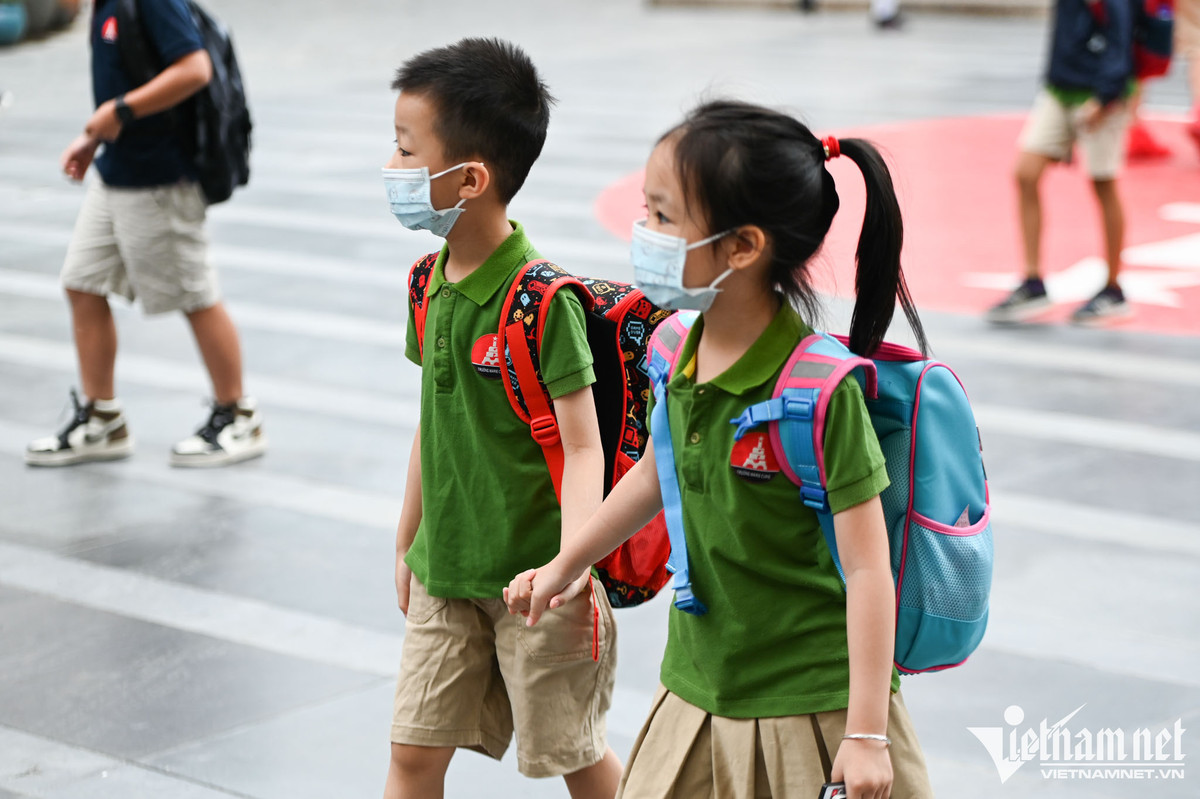 Các em học sinh trường Marie Curie dắt tay nhau vào trường lúc 6h45. Ảnh: Thạch Thảo.