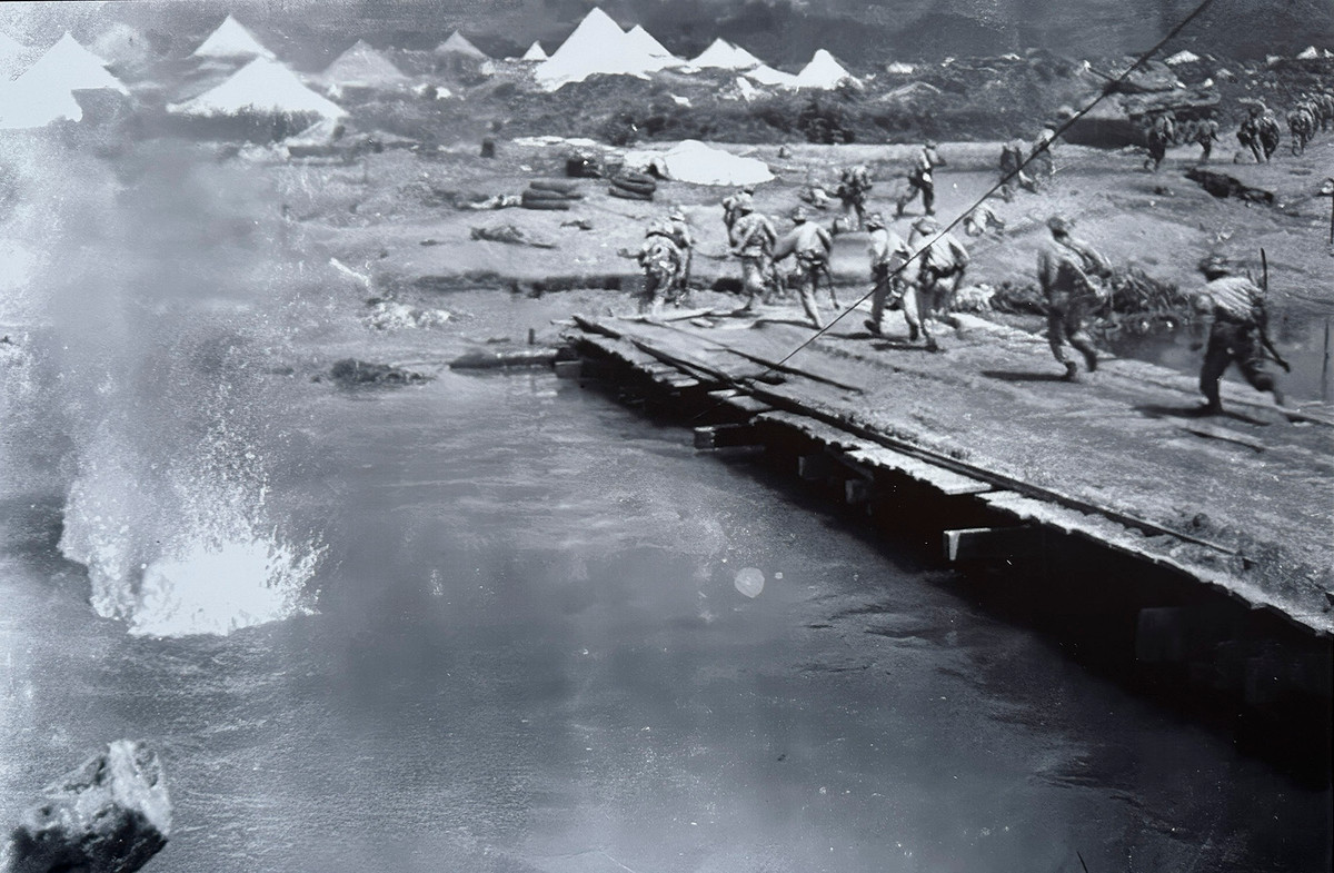 Bộ đội vượt cầu gỗ qua sông Nậm Rốm tấn công sân bay Mường Thanh.