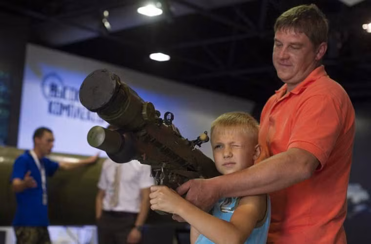 Cậu bé Nga đang ngắm bắn thử tên lửa vác vai đối không Igla với sự trợ giúp từ bố mình.