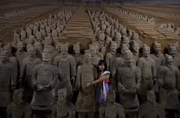 Thiếu nữ Trung Quốc hiện đại bên cạnh đội quân đất nung của Tần Thủy Hoàng có từ cách đây 2000 năm.