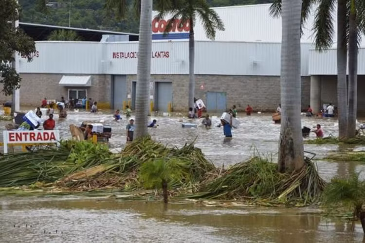 Dòng người lội nước đi mua đồ ở trung tâm thành phố Acapulco, trong ngày 17/9/2013.
