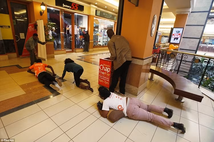 Mọi người bò sát đất để tránh đạn và thoát ra ngoài.