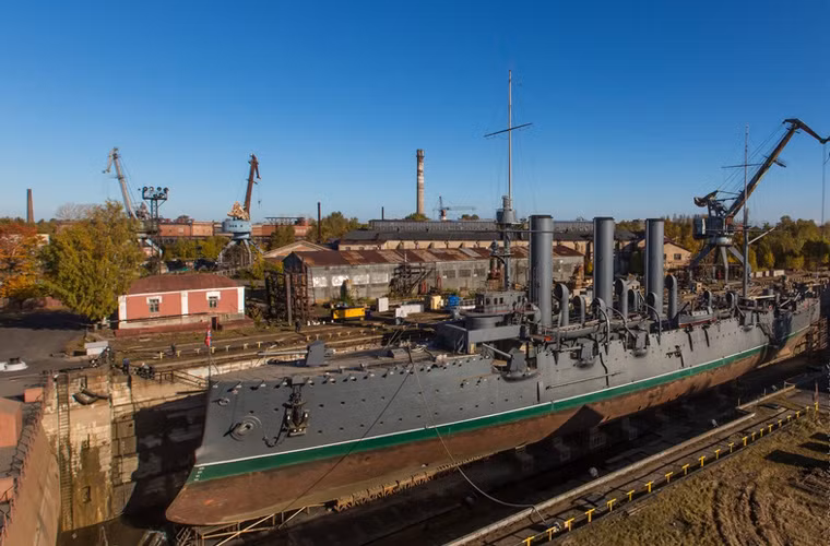 Trong ảnh, chiến hạm Rạng Đông – biểu tượng của Cách mạng tháng 10 Nga vĩ đại nằm bên trong khu vực sửa chữa trên cạn ở nhà máy Admiralty Verfi – nơi đang chế tạo các tàu ngầm Kilo cho Hải quân Nhân dân Việt Nam.