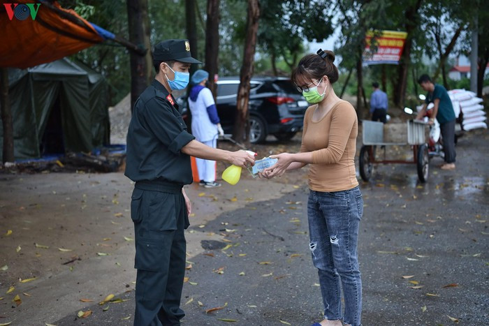 Người dân đi ra khỏi trạm điều được yêu cầu đeo khẩu trang, đo thân nhiệt và khử trùng toàn bộ, kể cả tiền mặt.
