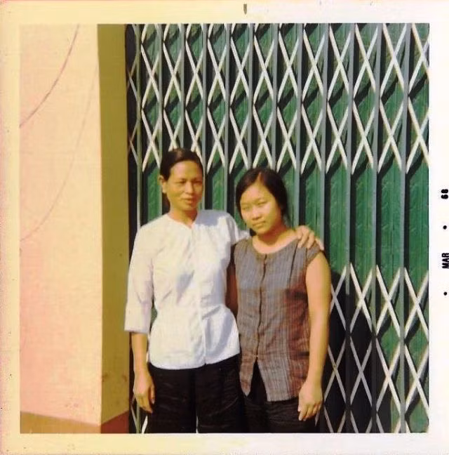 Hai phụ nữ An Lộc đứng trước cửa một ngôi nhà.