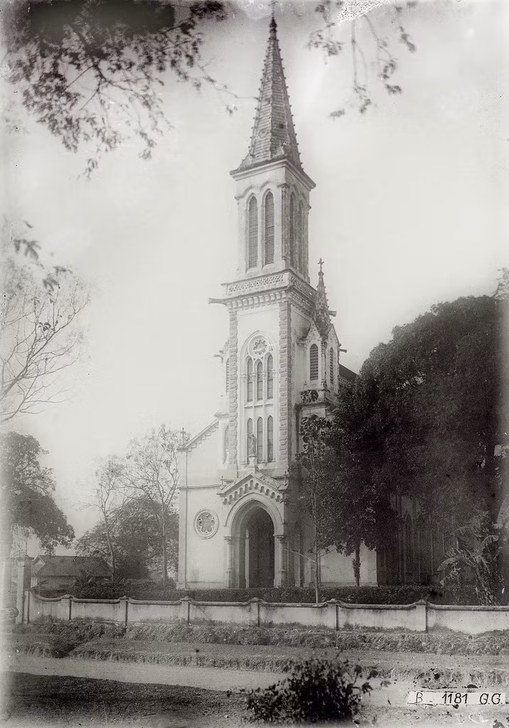 Mặt trước nhà thờ Huyện Sỹ, thập niên 1920. Công trình mang phong cách kiến trúc Gothic, được khởi công xây dựng năm 1902 theo thiết kế của linh mục Bouttier, đến năm 1905 thì được khánh thành.