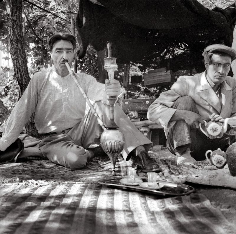 Những người đàn ông hút thuốc và uống trà tại một khu vườn.