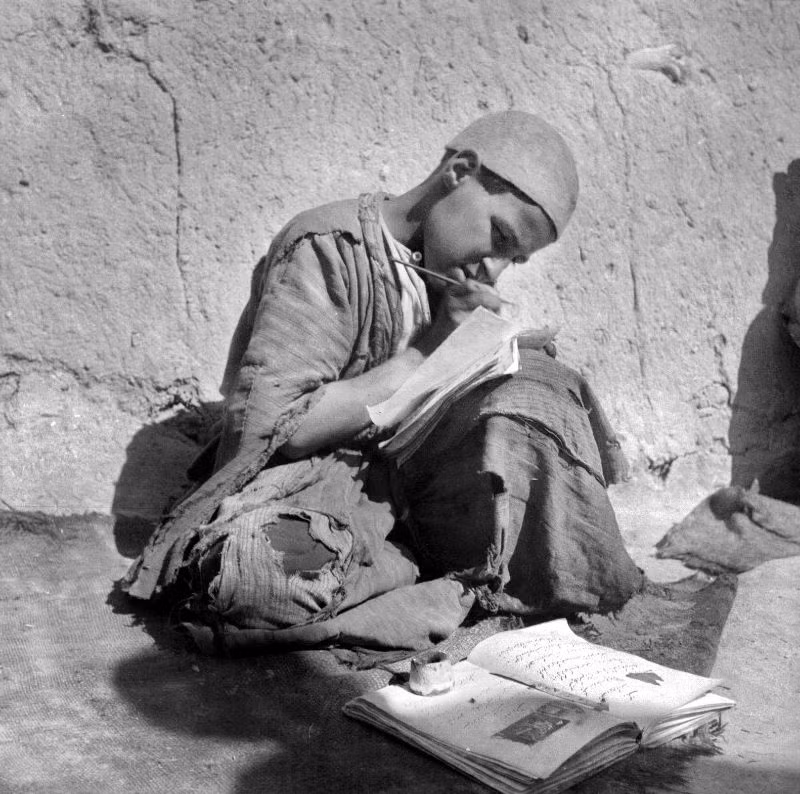 Cậu bé học bài bên ngôi nhà đắp bằng đất.