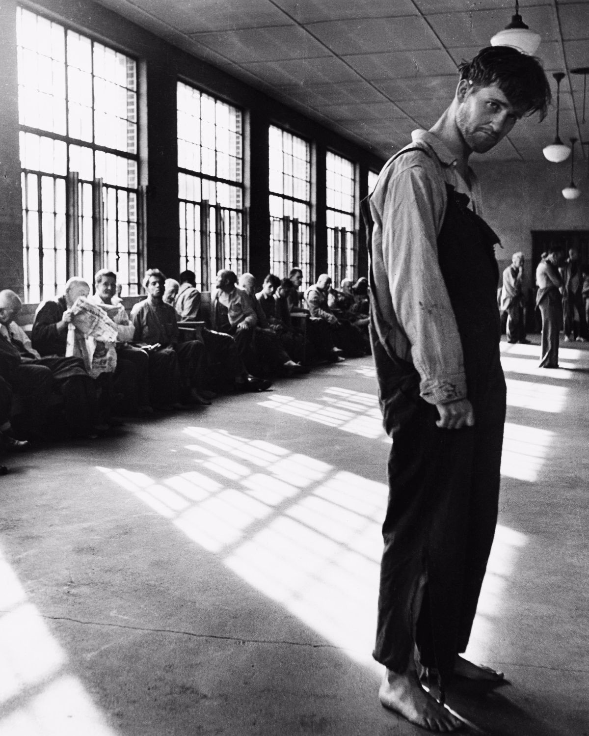 Vẻ mặt thất thần của một nam bệnh nhân trong phòng tập thể. Bài báo của Life mô tả điều kiện sống ở bệnh viện không khác một trại tị nạn, nơi bệnh nhân bị đối xử tệ và thường bị bỏ mặc trong nhiều ngày mà không có sự chú ý nào.