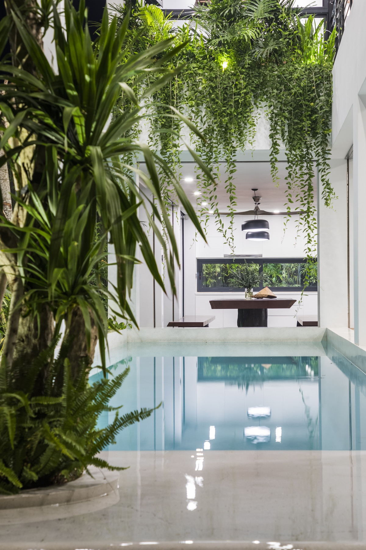 Dọc theo chiều dài nhà là bể bơi có kích thước 4x16m được bố trí cùng mảng cây xanh cao. Việc đặt hồ bơi tại vị trí này phát huy khả năng liên kết các không gian sinh hoạt theo chiều cao và chiều đứng.