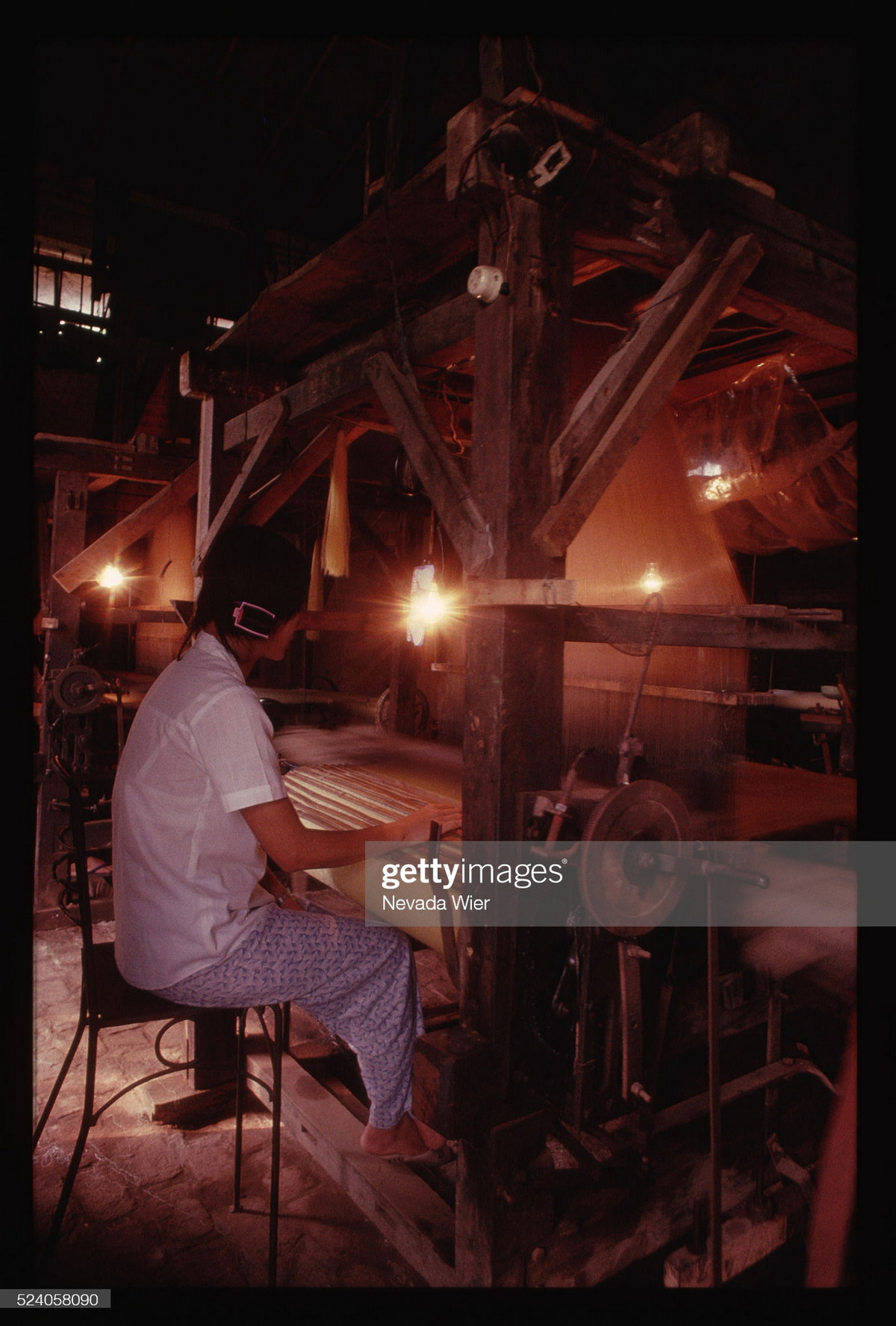 Người phụ nữ làm việc bên chiếc máy dệt thủ công ở làng lụa Vạn Phúc, tỉnh Hà Tây (nay thuộc quận Hà Đông, Hà Nội).