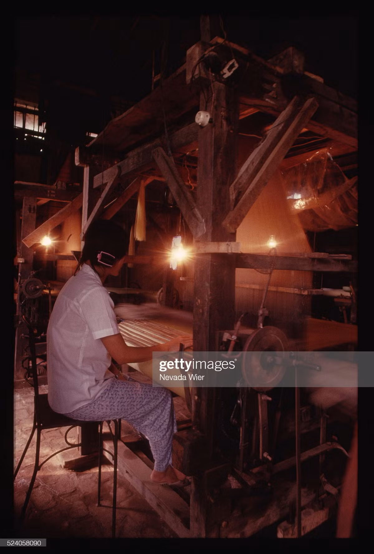 Người phụ nữ làm việc bên chiếc máy dệt thủ công ở làng lụa Vạn Phúc, tỉnh Hà Tây (nay thuộc quận Hà Đông, Hà Nội).