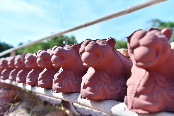 Sau khi tách khung, tượng hổ đất được phơi trên giàn khoảng 12 tiếng nếu trời nắng tốt, sau đó sẽ được cắt gọt cẩn thận và cho vài lò gạch để nung.