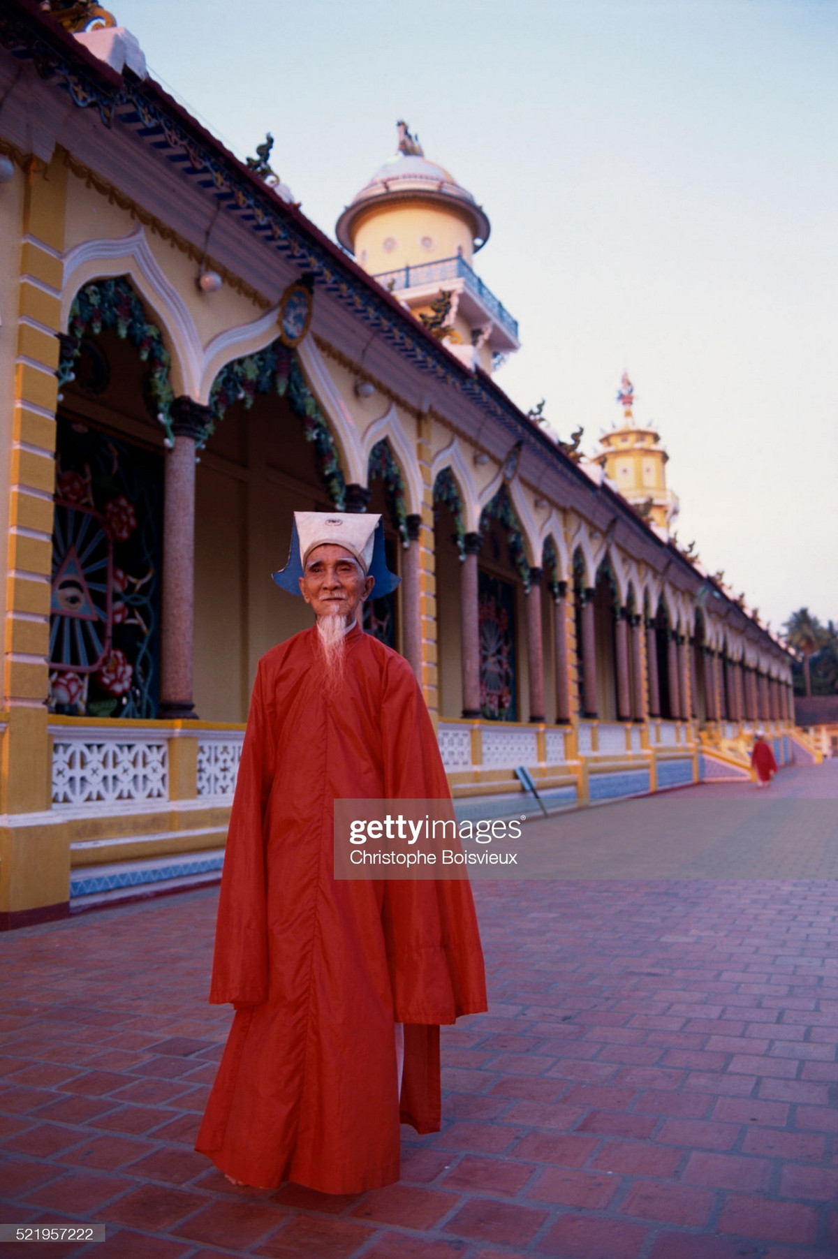 Vị chức sắc cao tuổi đứng trong khoảng sân lát gạch bao quanh Tòa thánh.