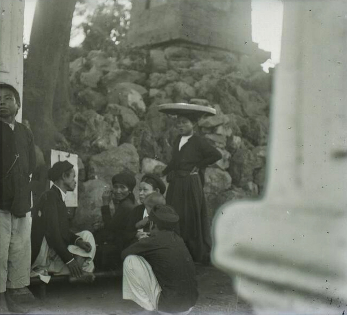 Các bà các cô tán chuyện với ông thầy bói cạnh tháp Bút, sau cổng Nghi Môn của đền Ngọc Sơn.