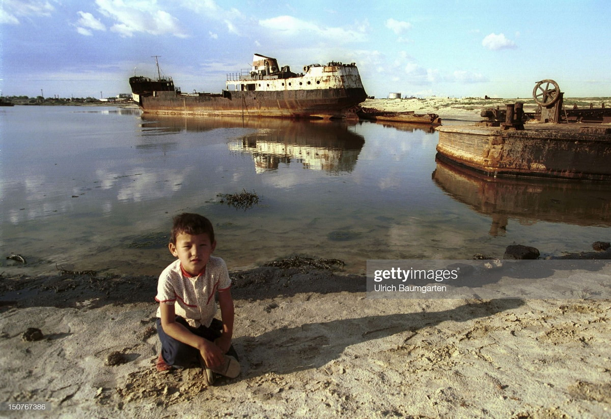 Đứa trẻ bên những xác tàu ở Aralsk, nơi từng là thành phố cảng sầm uất bên bờ biển Aral. Biển Aral từng là hồ nước mặn lớn thứ 4 thế giới, đã cạn khô do việc xây dựng các công trình thủy lợi lớn vào thập niên 1960.