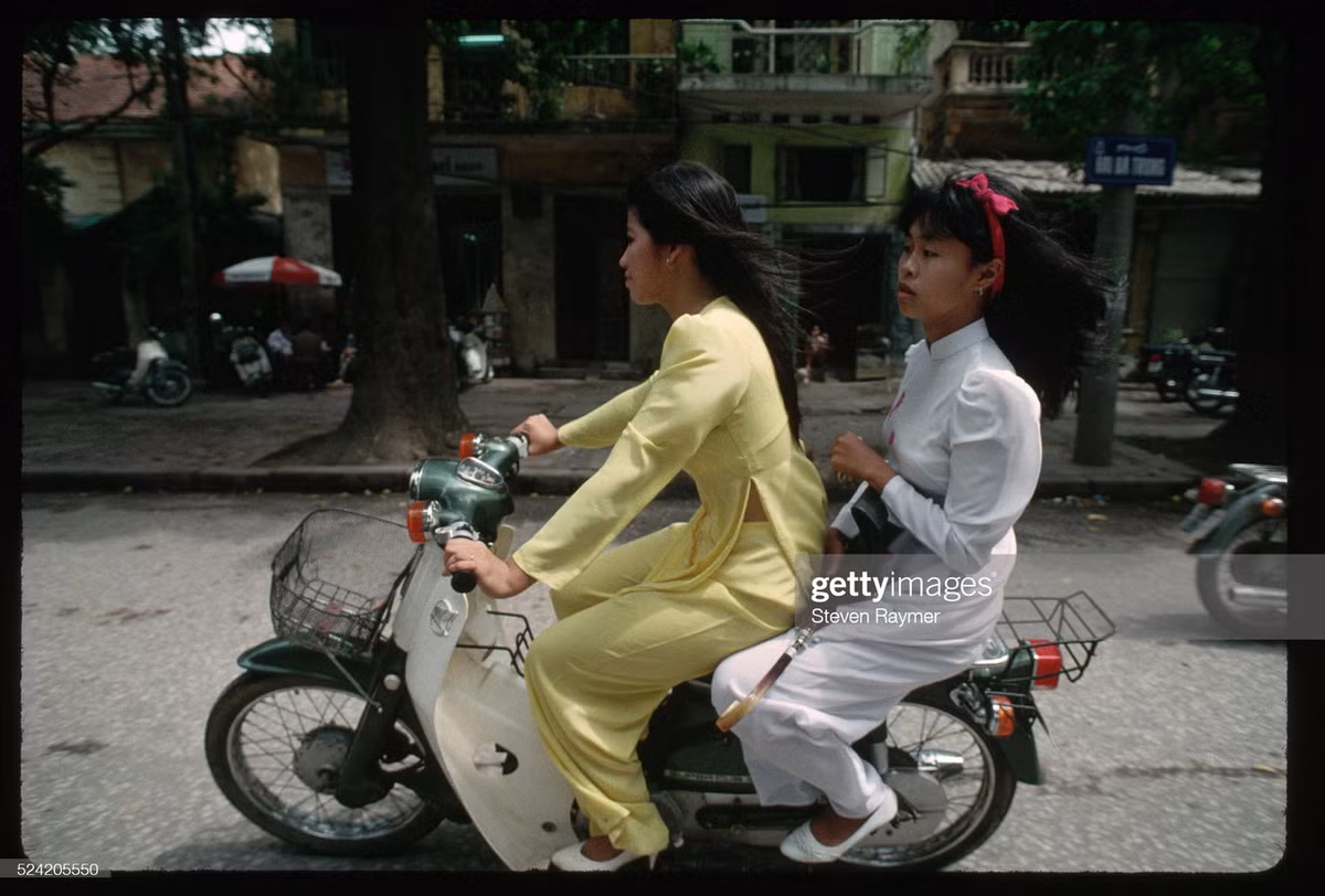 Hai nữ sinh chạy xe Honda Cub trên phố Hai Bà Trưng.
