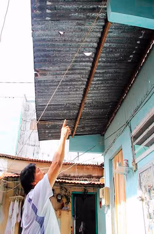 Một người dân cho biết lỗ thủng này trên mái tôn là hậu quả của những trái banh từ sân golf Tấn Trường bay qua.