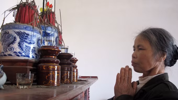 Bà Hòa thắp nén nhang cầu khấn cho em được an toàn và sớm trở về.