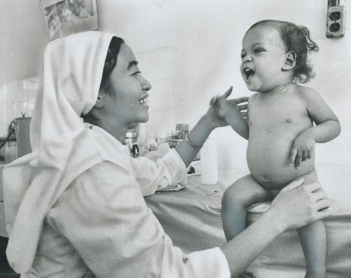 Một nữ tu đang dỗ dành đứa trẻ gào khóc.